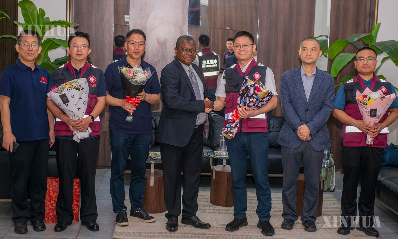 ကွန်ဂိုနိုင်ငံ (DRC) ကျန်းမာရေးဝန်ကြီးဌာန ကိုယ်စားလှယ် Luku Maleyo Marius (အလယ်) က တရုတ်နိုင်ငံ၏ ဒုတိယအသုတ် အီဘိုလာရောဂါတိုက်ဖျက်ရေး ဆေးဘက်ဆိုင်ရာ ကျွမ်းကျင်ပညာရှင်အဖွဲ့အား ကွန်ဂိုနိုင်ငံ (DRC) မြို့တော် ကင်ရှာဆာ လေဆိပ်တွင် လာရောက်ကြိုဆိုနေသည်ကို ၂၀၂၆ ခုနှစ် ဇူလိုင် ၃ ရက်က တွေ့ရစဉ် (ဆင်ဟွာ)
