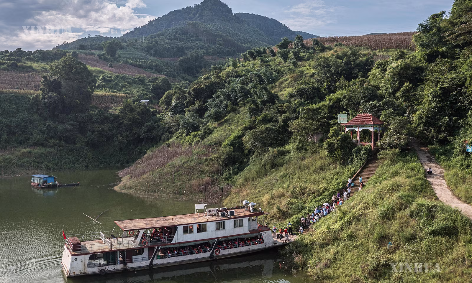 တရုတ်နိုင်ငံ ယူနန်ပြည်နယ် ဝန်ဆန်း ကျွမ့်လူမျိုး မြောင်လူမျိုး ကိုယ်ပိုင်အုပ်ချုပ်ခွင့်ရပြည်နယ်ခွဲ ဖုနင်ခရိုင် ပေါအိုက်မြို့နယ် ပန်သာလှေဆိပ်တွင် ကျောင်းသား၊ ကျောင်းသူများအား ကြိုဆိုနေသည့် ကူးတို့လှေကို ၂၀၂၆ ခုနှစ် ဩဂုတ် ၃၀ ရက်က တွေ့ရစဉ် (ဆင်ဟွာ)