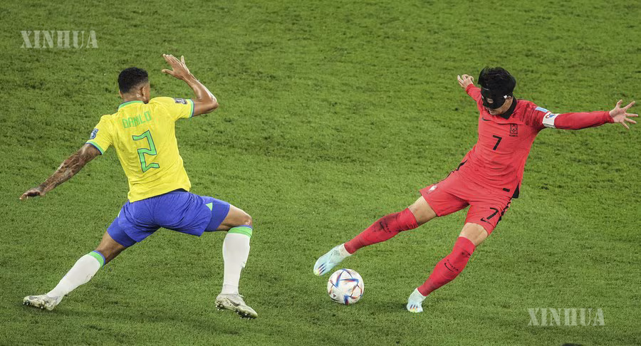 ကာတာနိုင်ငံ ဒိုဟာမြို့ရှိ Stadium 974 အားကစားရုံတွင် ၂၀၂၂ ခုနှစ် ဖီဖာ ကမ္ဘာ့ဖလားပွဲ၊ ၁၆ သင်းအဆင့်ပွဲစဉ်အတွင်း ဘရာဇီးအသင်းမှ ဒန်နီလိုနှင့် တောင်ကိုရီးယားအသင်းမှ Son Heung-min (ယာ) တို့ ယှဉ်ပြိုင်ကစားနေသည်ကို ၂၀၂၂ ခုနှစ် ဒီဇင်ဘာ ၅ ရက်က တွေ့ရစဉ် (ဆင်ဟွာ)